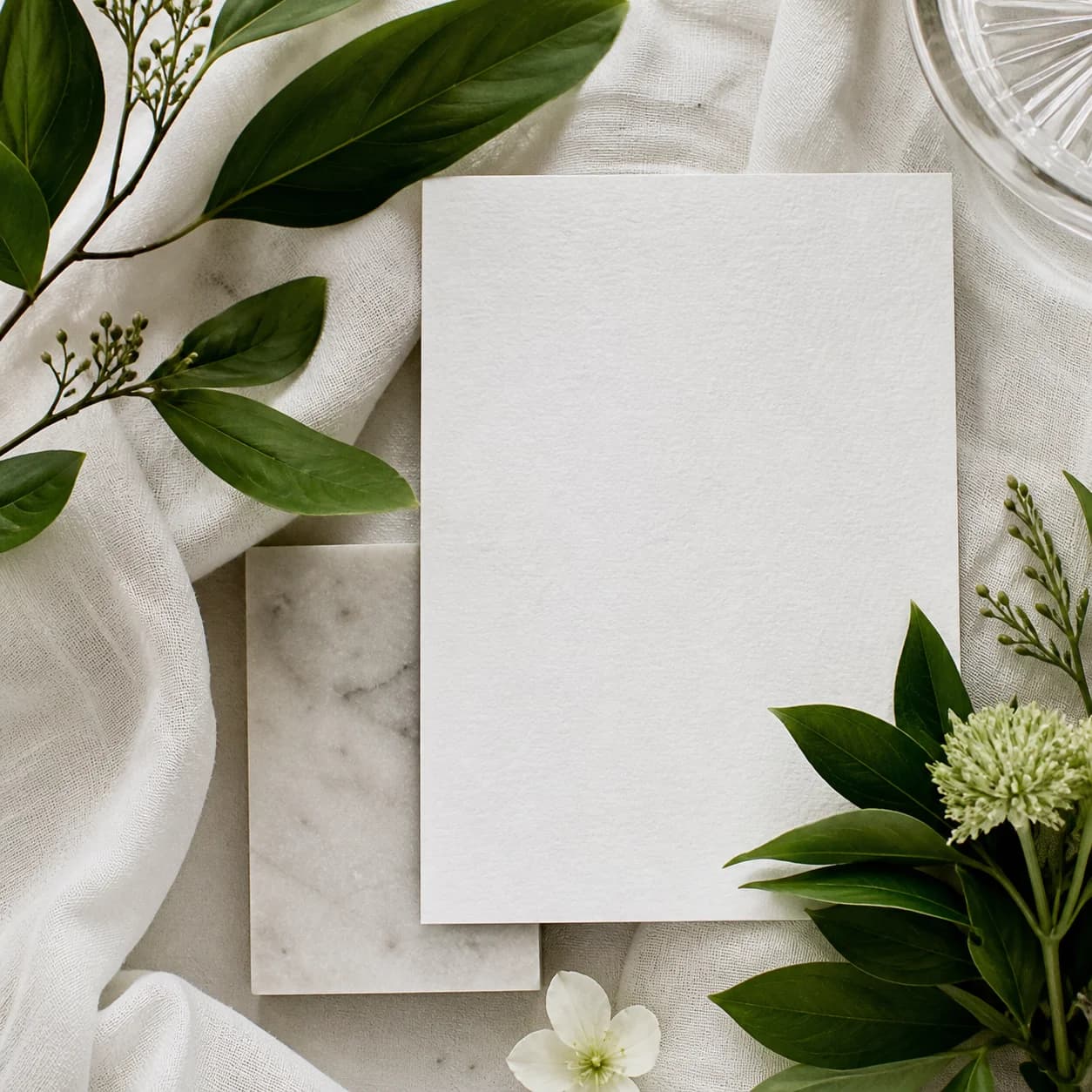 Illustration générée par IA — papier blanc texturé, lin clair, pierre et feuillage pour une composition de matières d’inspiration Jardin.